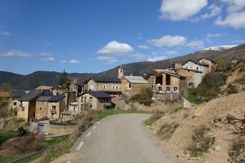 a small village in the mountains with a road going through it