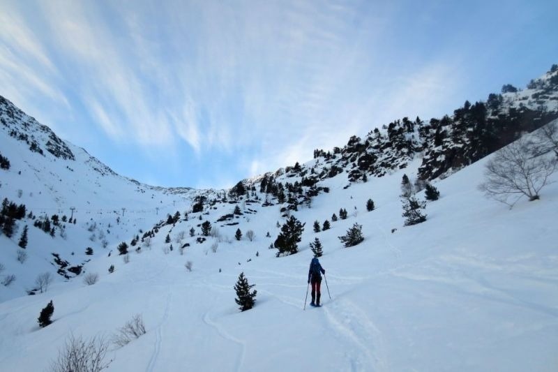 un excursionista camina a través d' una vall coberta de neige