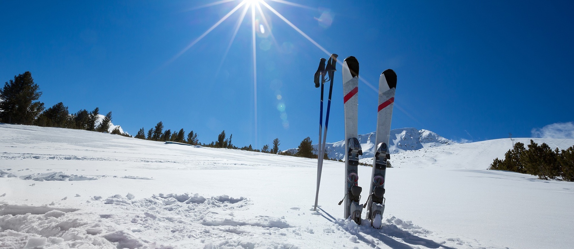 une paire de skis et des bâtons sont posés dans la neige