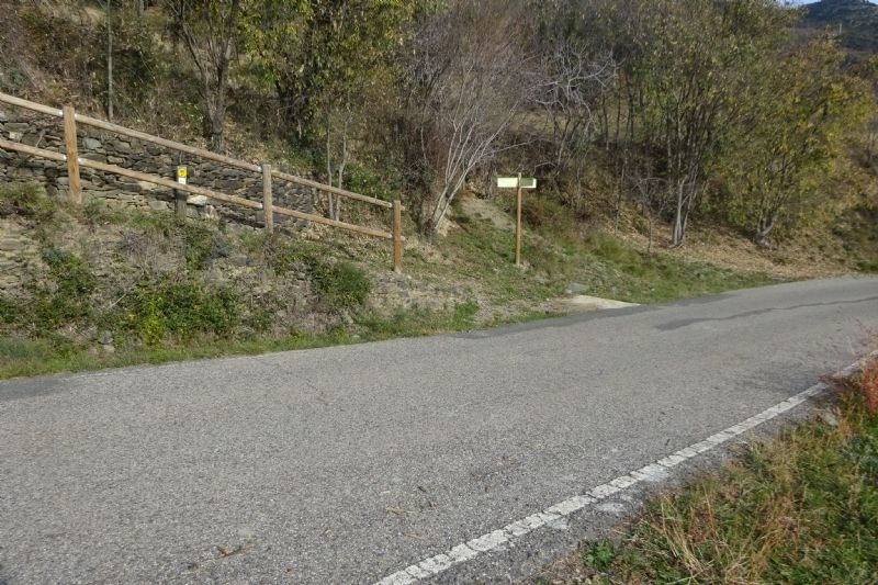 una carretera a l' esquerra de la qual hi ha un cartell
