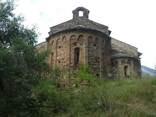 une vieille église en pierre est entourée d' arbres et d' herbe .