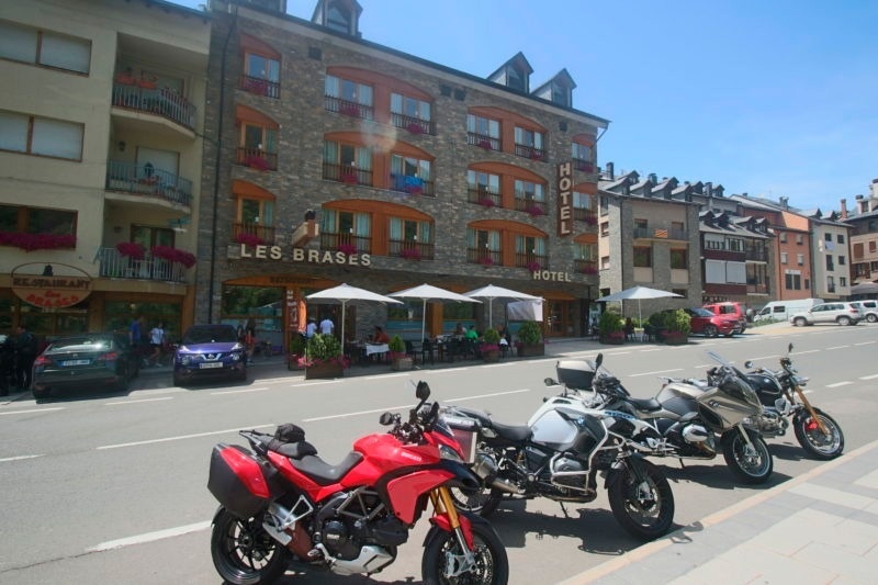 varias motocicletas están estacionadas frente al hotel les brases