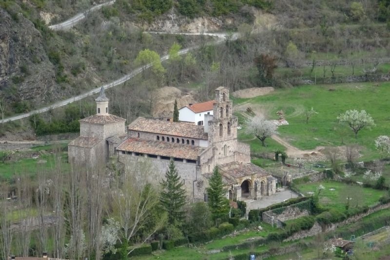an aerial view of a church surrounded by trees and grass