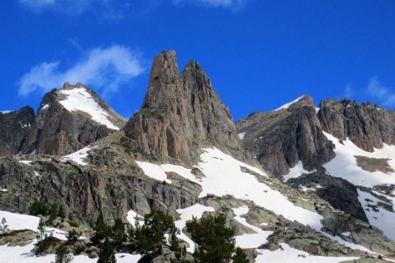montañas cubiertas de nieve y rocas con un cielo azul en el fondo