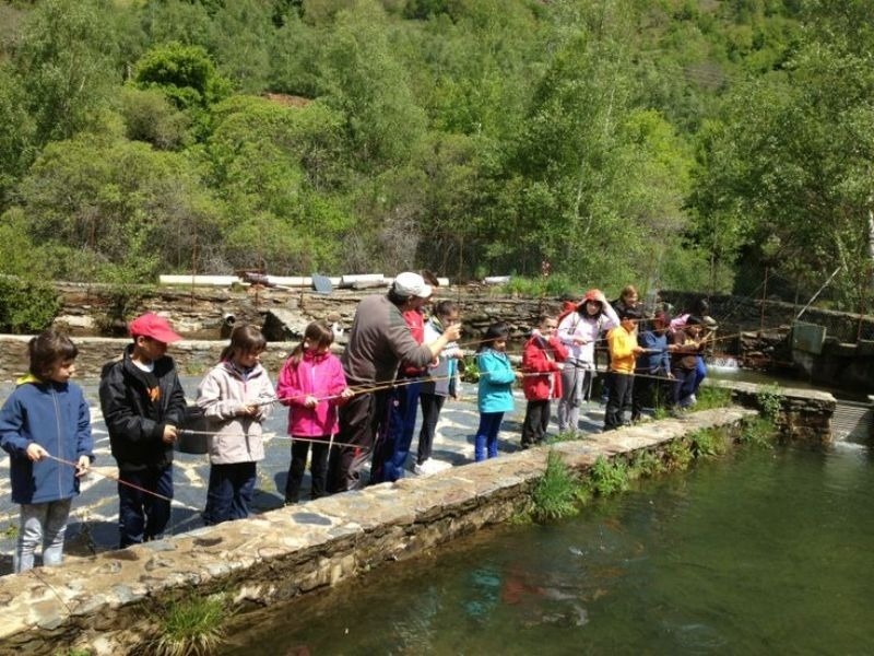 un grup d' adults i nens pescant en un riu