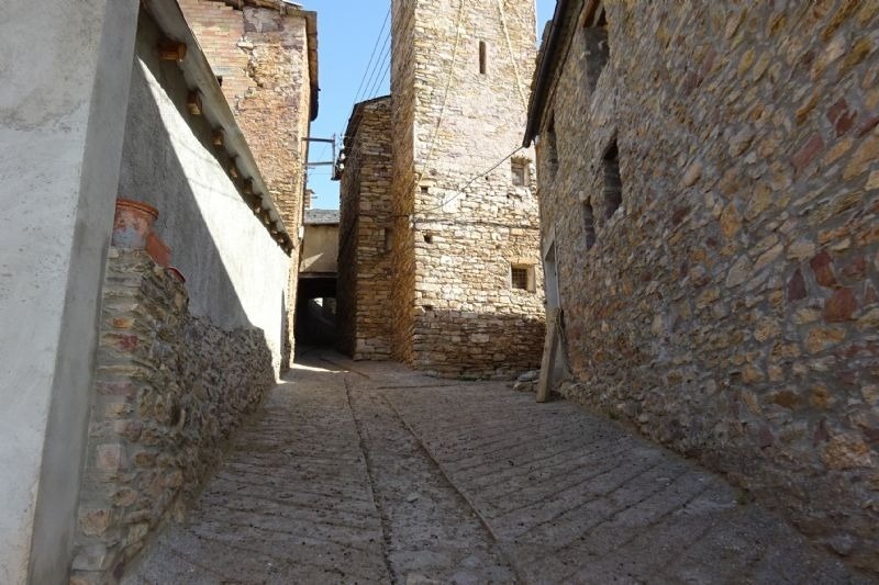 a narrow stone alleyway between two stone buildings