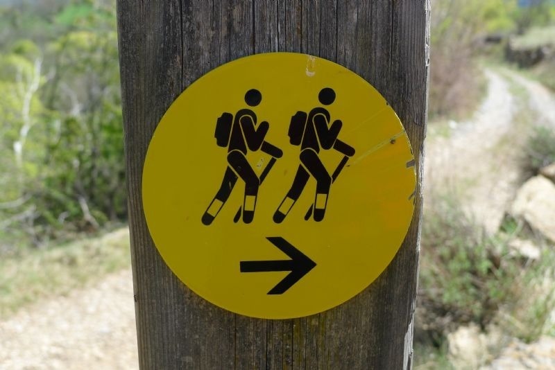 a yellow sign with two people and an arrow pointing to the right