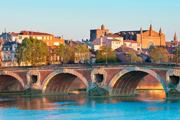 a bridge over a body of water with buildings in the background