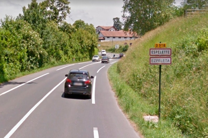 un coche conduce por una carretera con un letrero que dice espelette ezpeleta