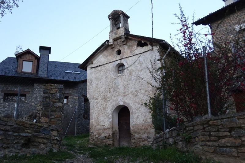 a small stone building with a bell tower on top of it