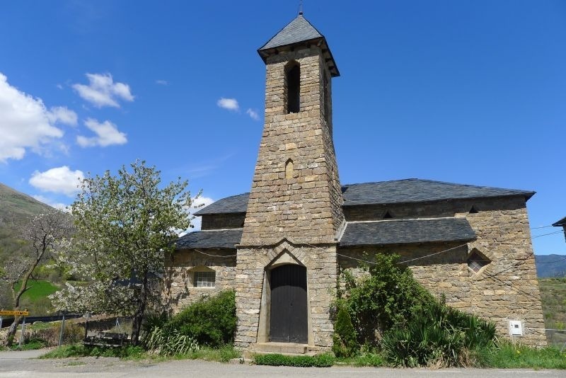una iglesia de piedra con un techo de pizarra y un campanario