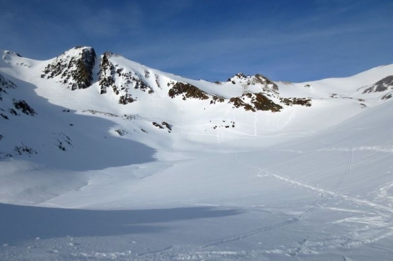 una vall coberta de neige avec des montagnes en arrière-plan