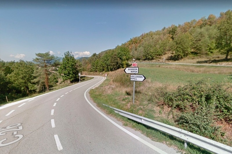 a sign on the side of a road shows the way to a village
