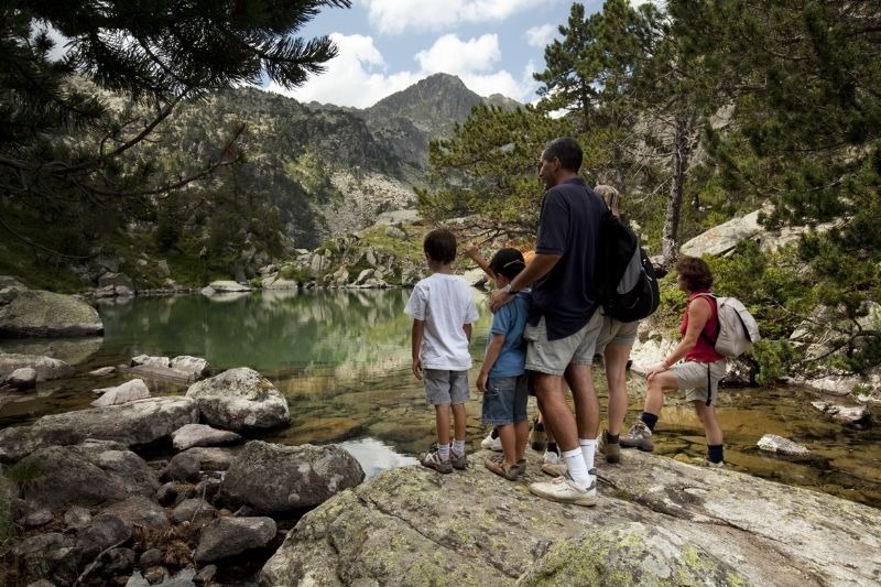 un grupo de personas miran un lago en las montañas