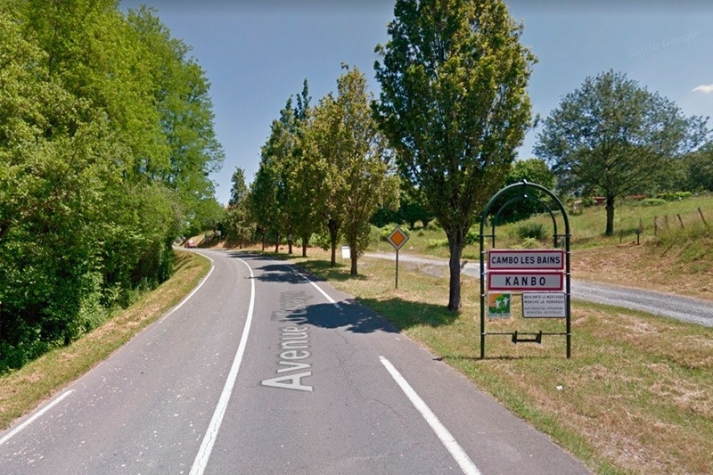 una carretera a través d' un bosc amb un cartell que diu kanbo