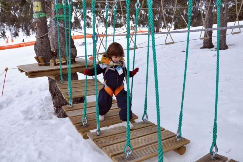 un niño camina por un puente de madera en la nieve