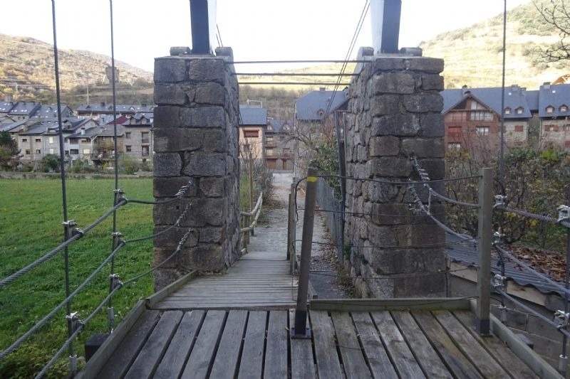 un pont de corda a través d' un riu a un pueblo