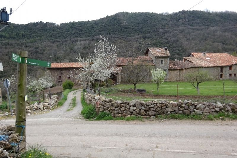 a sign on the side of a road shows the way to a village