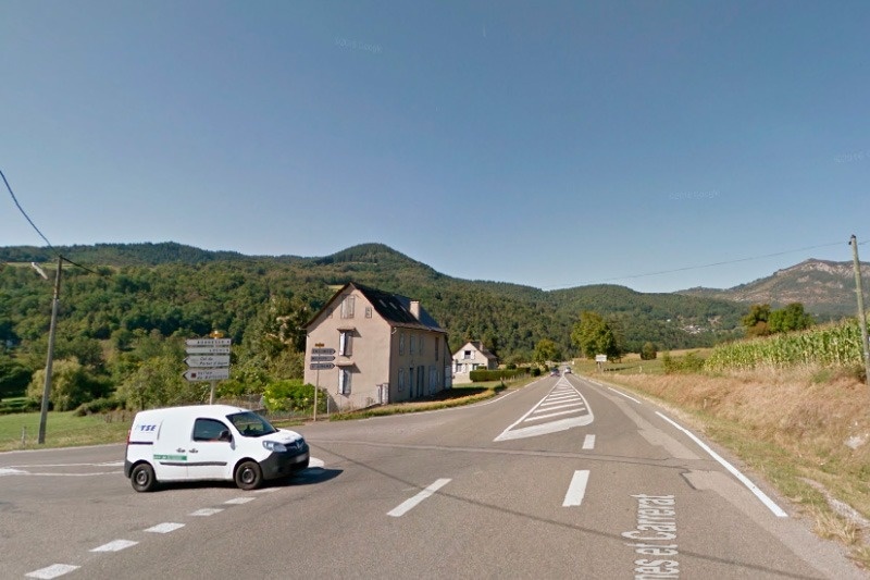 una furgoneta blanca conduce por una carretera con la palabra general a la izquierda