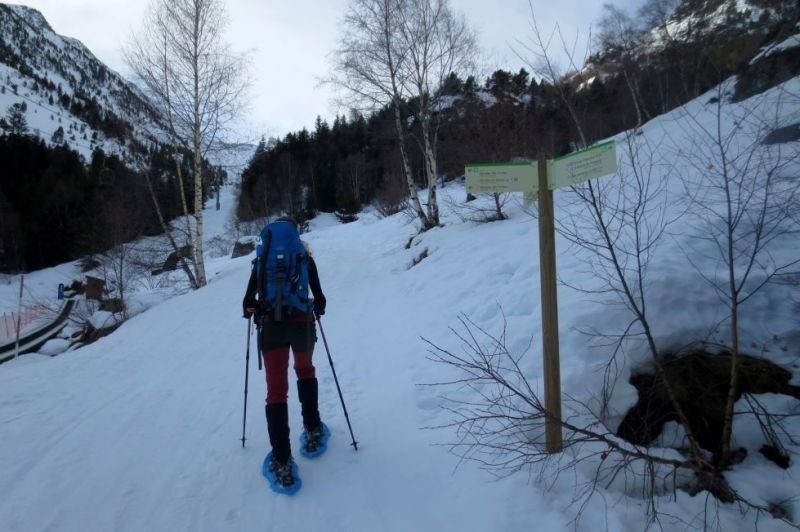 una persona amb una mochila camina a través de la nieve