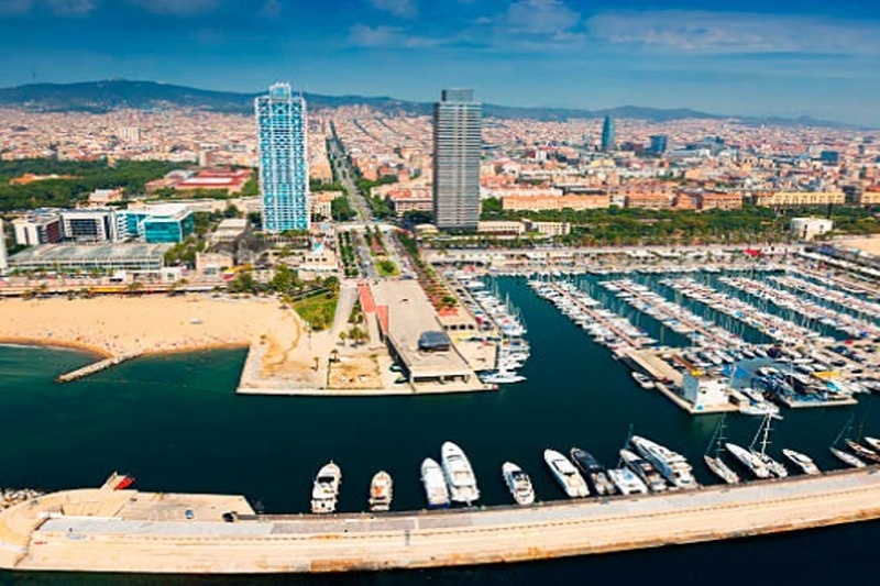 an aerial view of a marina with boats docked and a city in the background
