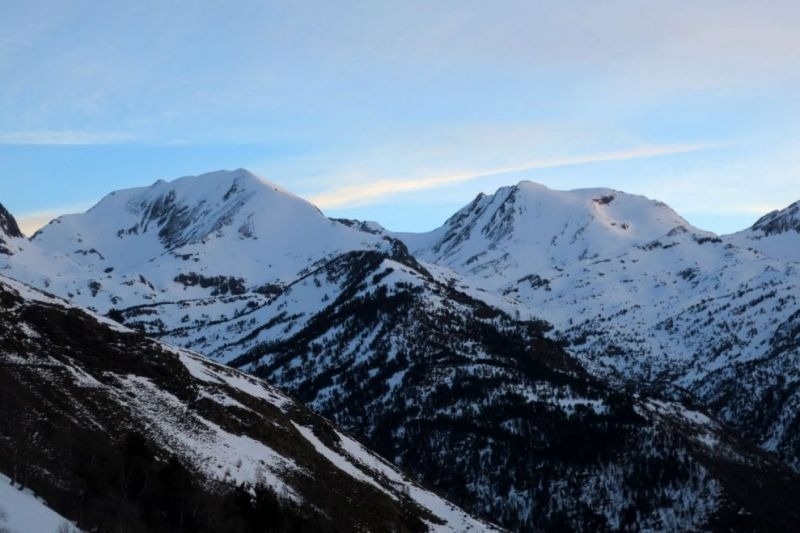 un paisatge de montagnes cobertes de neige avec un ciel bleu en arrière-plan