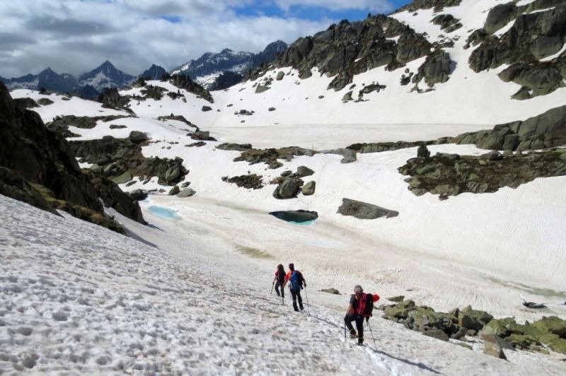 un grupo de personas camina por la nieve en las montañas