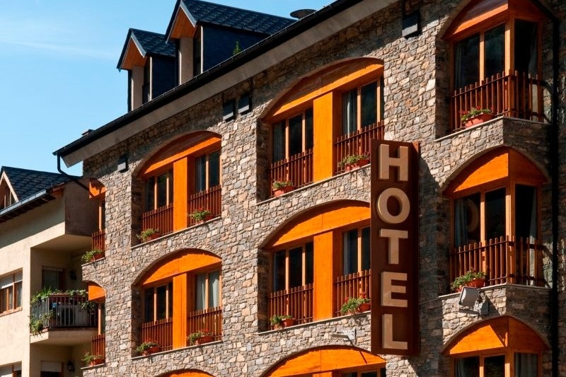 un grand bâtiment en pierre avec un panneau d' hôtel au sommet