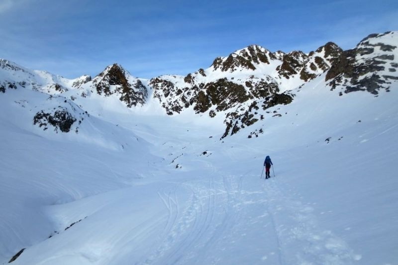 una persona camina per una vall coberta de neige