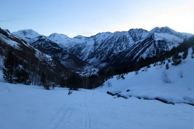 una carretera coberta de neige s'envolta en un paisatge de montagnes enneigées