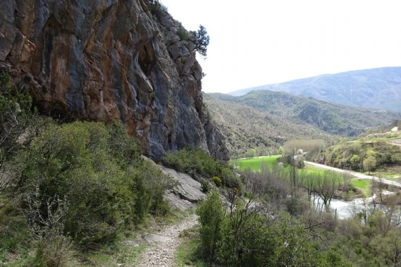 un camino a lo largo de un acantilado con un río en el fondo