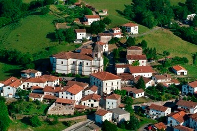 una vista aérea de un pequeño pueblo con edificios blancos y techos rojos