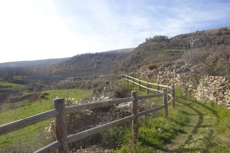 una cerca de madera a l' esquerra d' un camí