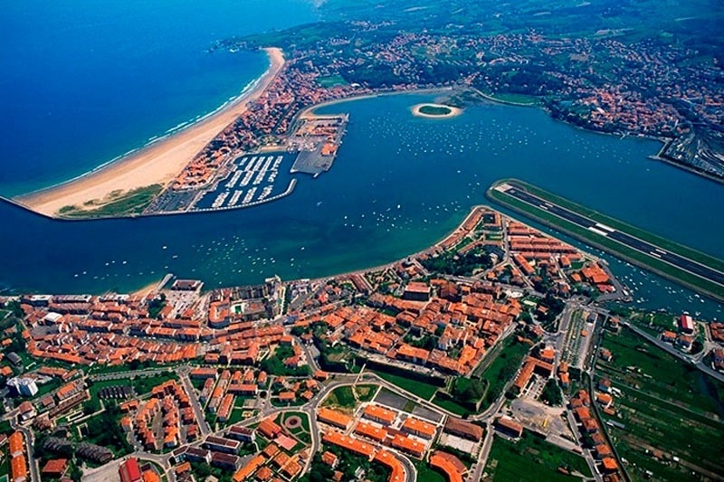 an aerial view of a city with a large body of water surrounding it