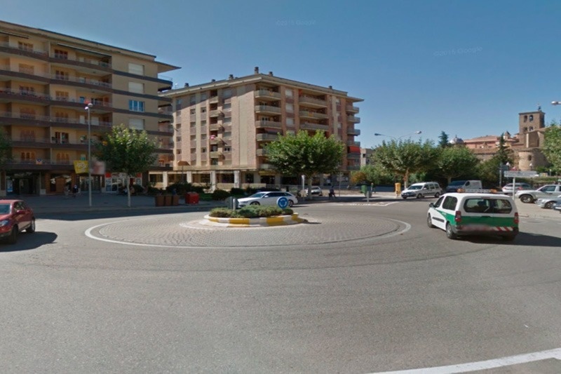 a green and white van is driving around a roundabout