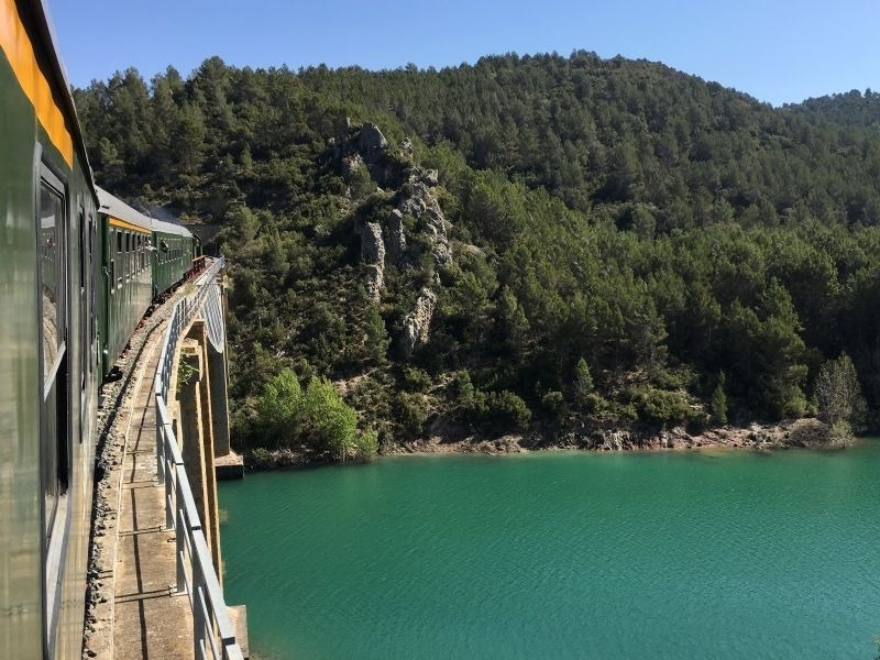 a train is going over a bridge over a lake