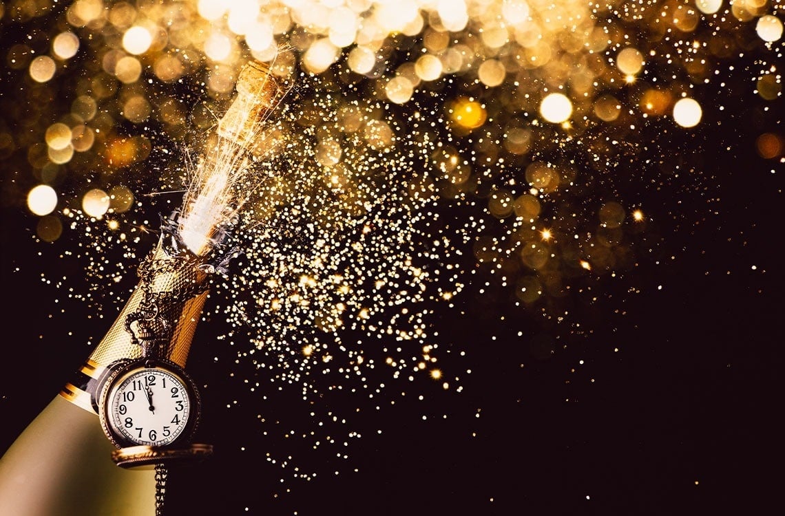 une bouteille de champagne avec une horloge à côté d' elle