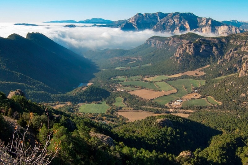 un valle rodeado de montañas cubiertas de nubes