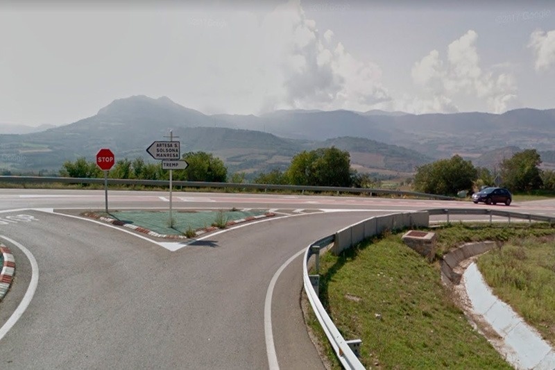 un panneau d' arrêt est à l' intersection d' une route avec des montagnes en arrière-plan