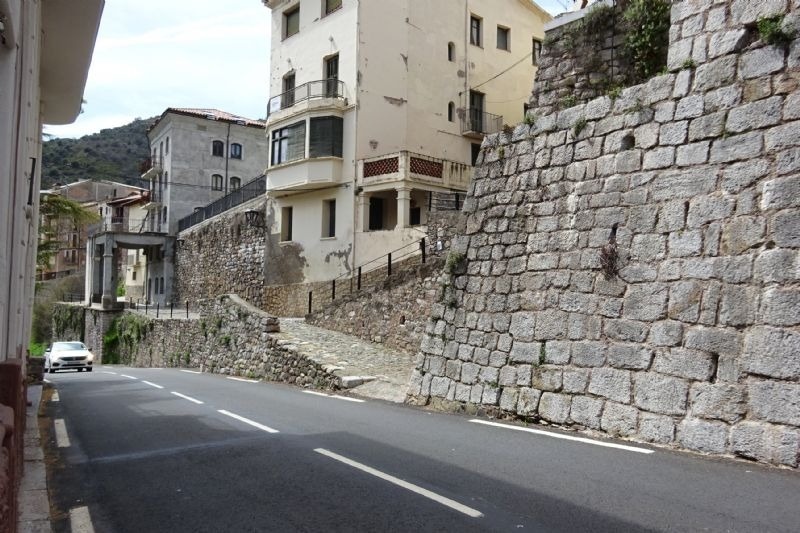 un edificio en la ladera de una colina junto a una carretera