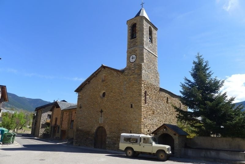 a white truck is parked in front of a stone church