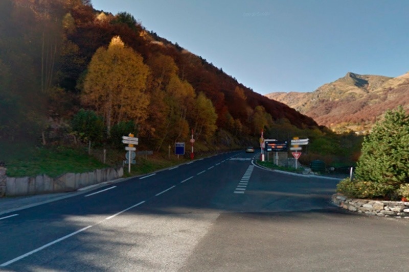 une route dans les montagnes avec des panneaux de signalisation