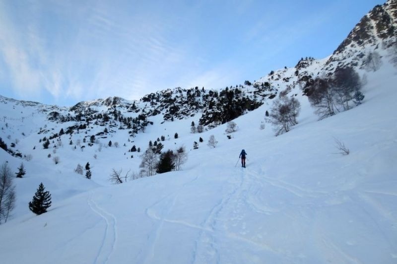 una persona camina per la nevada a la ladera d' una montagna