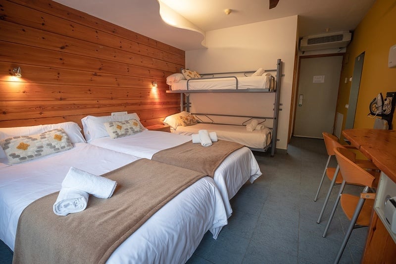 QUADRUPLE ROOM - a hotel room with two beds and a bunk bed