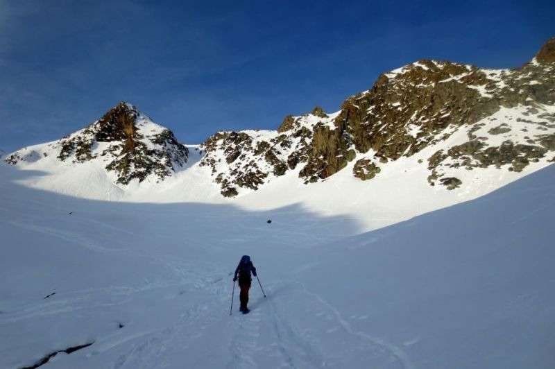 un excursionista camina a través d' una vall coberta de neu
