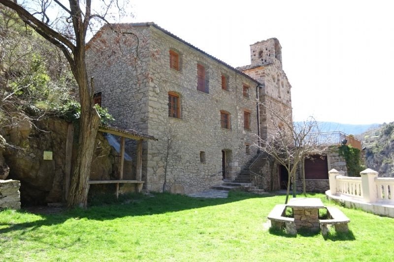 un edificio de piedra con escaleras y una mesa de picnic al frente