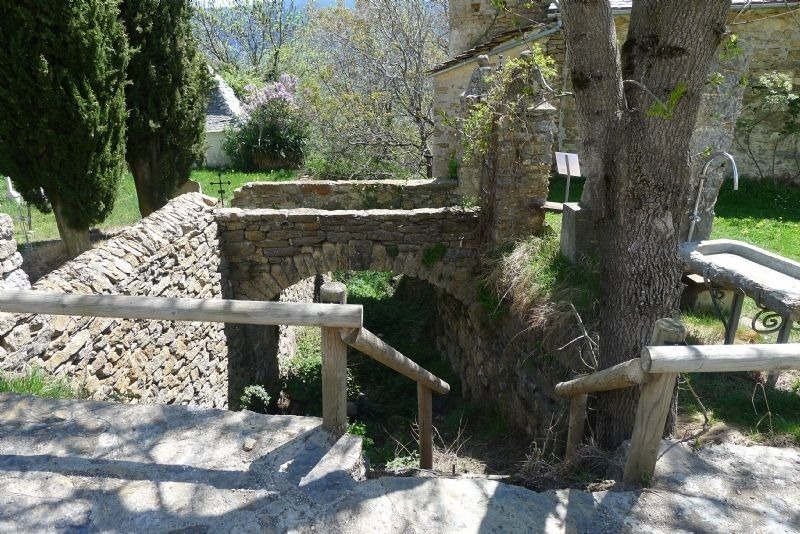 stairs leading up to a stone wall with a wooden railing