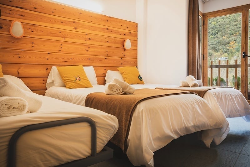 TRIPLE ROOM - a bedroom with three beds and a wooden headboard