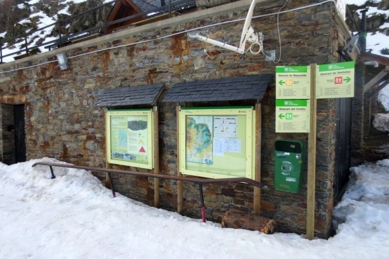 un edifici de pedra cobert de neu i algunes cartes
