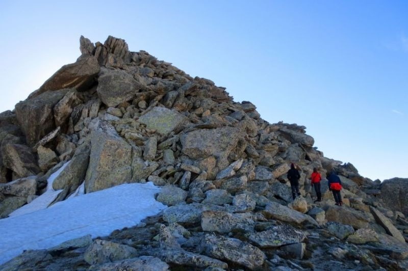 un grupo de personas sube una montaña rocosa